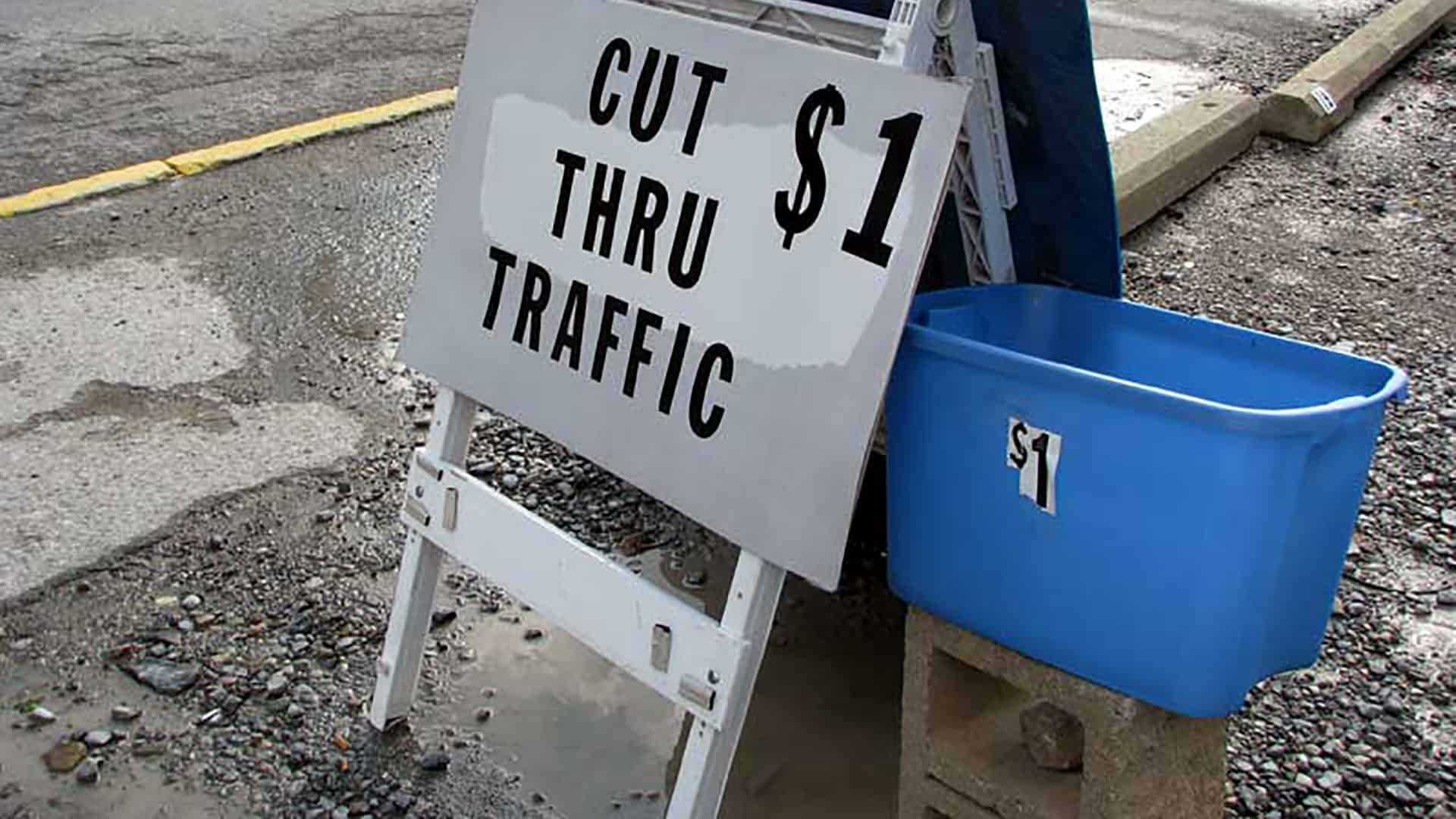 standstill-traffic-header A sign reading: Cut thru traffic $1.